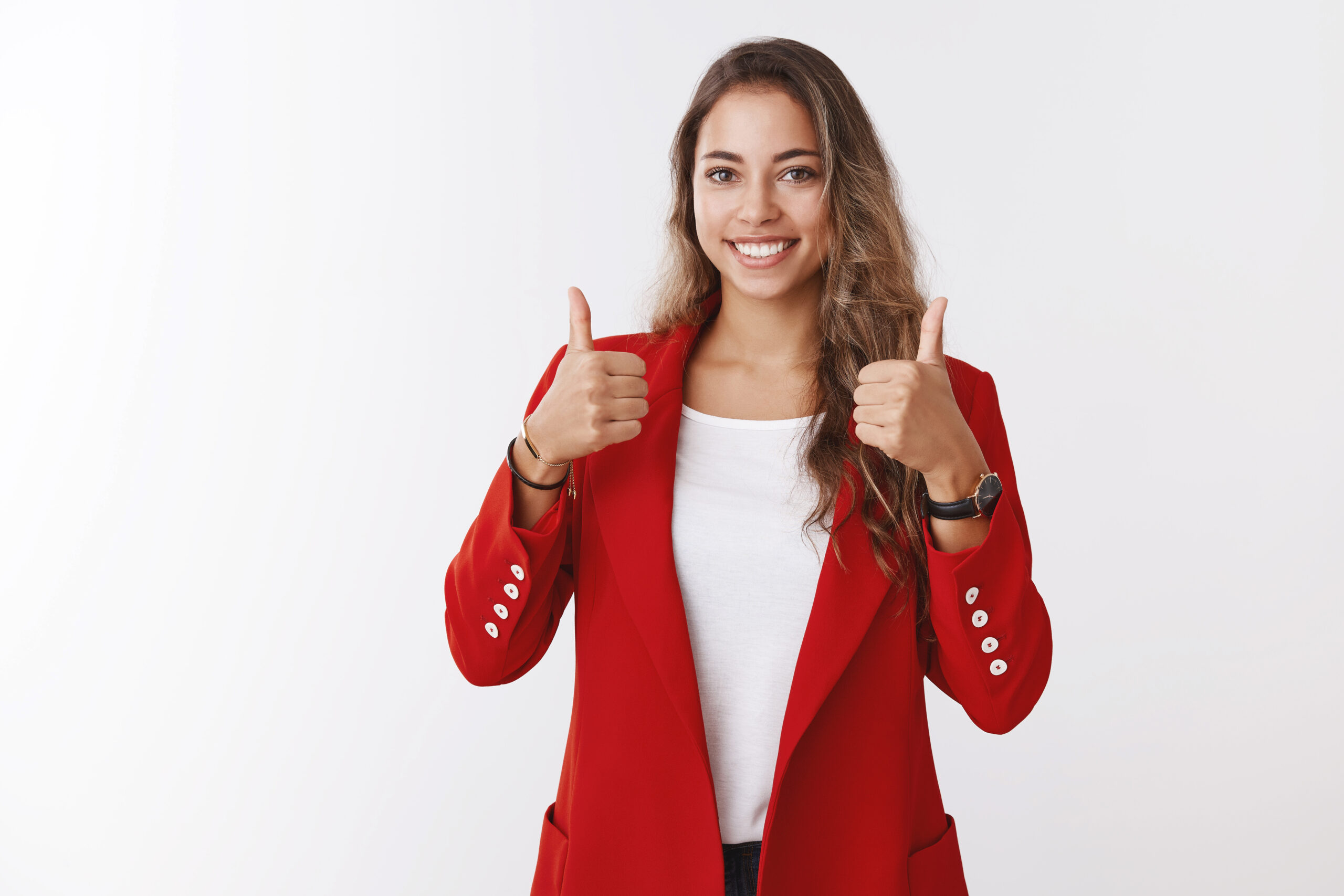 A young woman in a red blazer smiles confidently, giving thumbs up. She represents facility management with a cheerful expression.